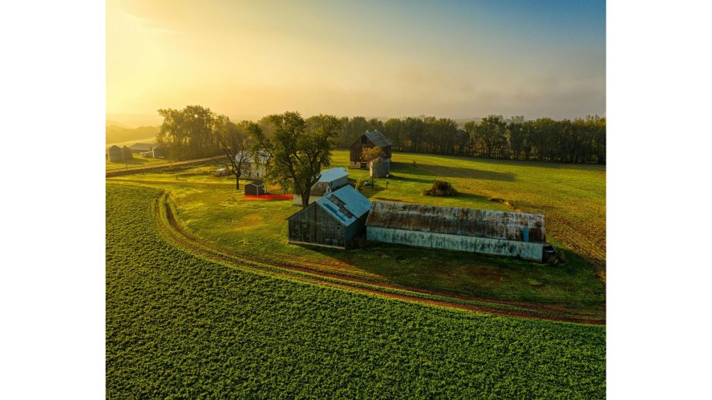 Rural farmhouse and farmland landscape representing private well water conditions in agricultural areas